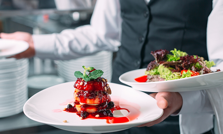 Waiter serving in motion on duty in restaurant. The waiter carri