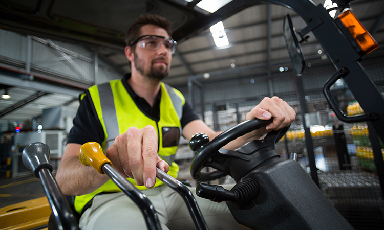 Factory worker driving forklift